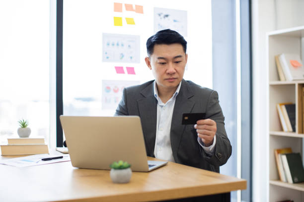 istock Asian businessman using laptop for online financial transaction 2184270343