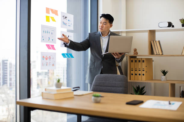 istock Asian businessman presenting data during video call in modern office 2184271394