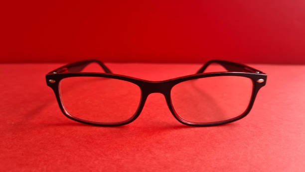 istock Simple black glasses placed on a vibrant red background, showcasing contemporary eyewear design and color contrast concept 2184271714