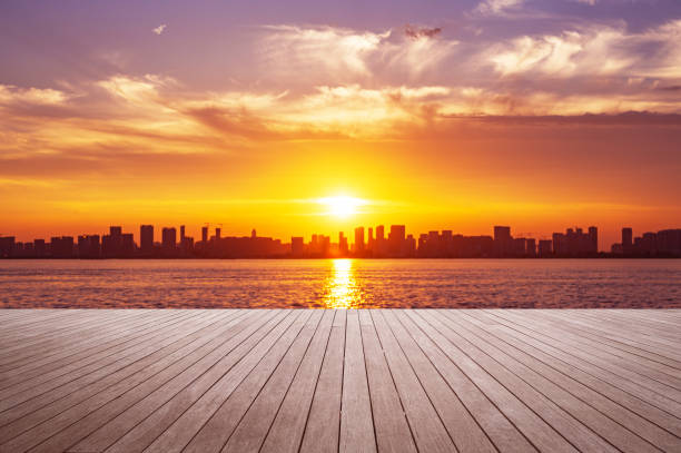 istock Empty wooden viewing platform and modern urban skyline with dramatic sky and clouds during sunset 2184271749