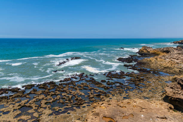 Coast and ocean waves crashing against the rocky coastline of Essaouira.
