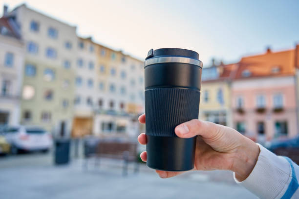 Woman holding reusable coffee cup outdoors. Concept of sustainable and eco-friendly living