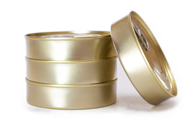 Stacked tin cans and metal containers creating a food stockpile in dark pantry