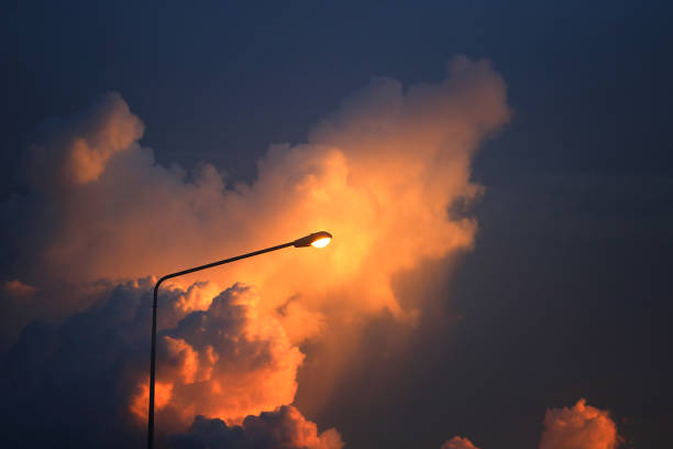 street lamp illuminated against Dramatic Clouds at sunset