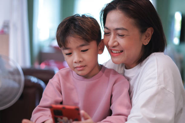 istock Mother and son are using mobile phones to watch and learn online. 2184286539