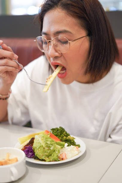 istock Women eat vegetables on the dining table. 2184286591