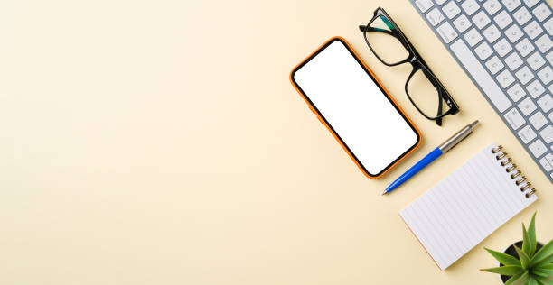 istock Office desk with computer keyboard, mouse, smartphone, notebook and pen. Top view with copy space. Flat lay 2184287525
