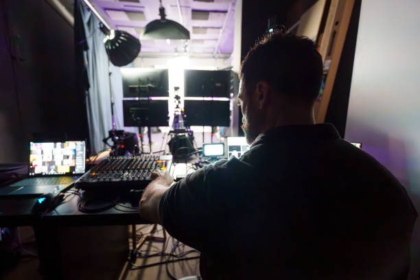 istock Experienced Mature Male TV Director Operating Control Panel in Studio During Live Streaming Production 2184288138