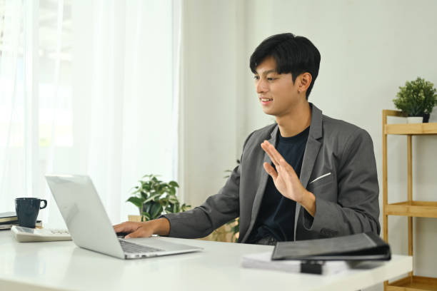 istock Smiling Man Greeting Colleagues During a Virtual Meeting 2184288471