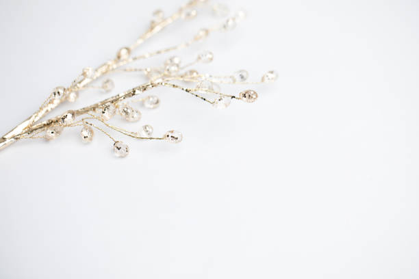 Crystal beads on a golden branch on white background, Christmas concept