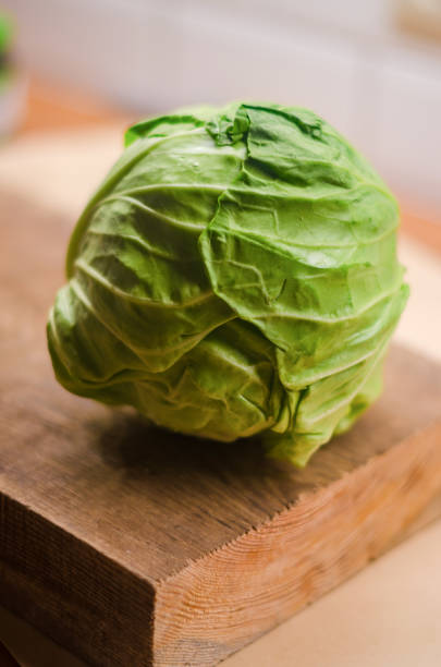 istock fresh cabbage on wooden cutting board in the kitchen 2184290382