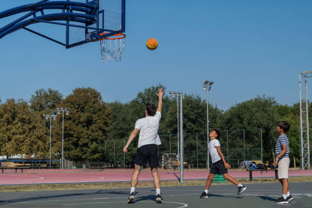 istock Boys participate in outdoor basketball training with a coach, focusing on skill development, teamwork, and fitness in a fun, structured environment, enhancing their athletic skills and confidence 2184291385
