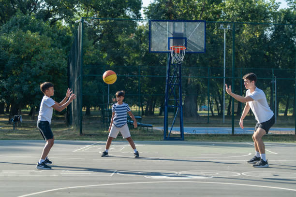 istock Boys participate in basketball training outdoors with a coach, practicing skills and teamwork. The session promotes fitness, sportsmanship, and skill-building in a fun, supportive environment 2184292318