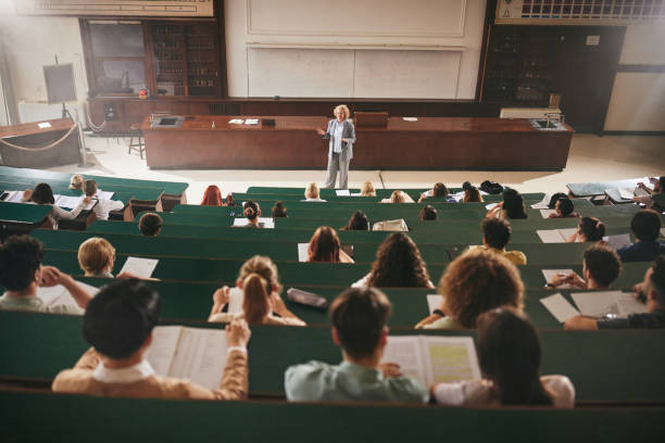 istock Happy university professor giving a lecture to her students in amphitheater. 2184292959