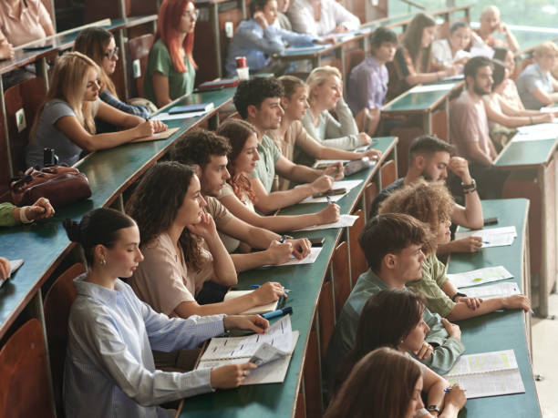 istock Crowd of college students attending a class at lecture hall. 2184293245