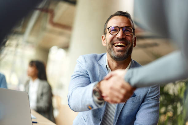 happy businessman shaking hands with his colleague on a meeting in the office. - businessman foto e immagini stock