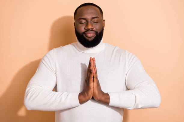 istock Photo of cute relaxed young guy dressed white pullover arms together practicing yoga isolated beige color background 2184296652