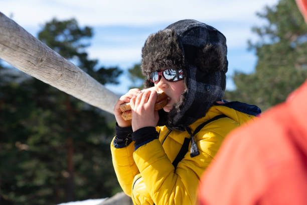 Boy eating a sandwich on a break from a day in the snow skiing