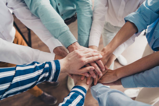 istock Cropped photo of coworking project teamwork people hold hands support work together conference meeting successful nice light office 2184301829
