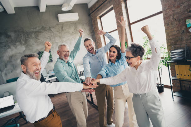 istock Photo of teamwork people working win celebrate hold hands support together  comfortable modern office loft room interior indoors workspace 2184301851