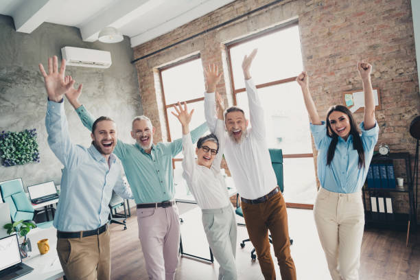 istock Photo of teamwork people working together raise hands excited celebration comfortable modern office loft room interior indoors workspace 2184302001