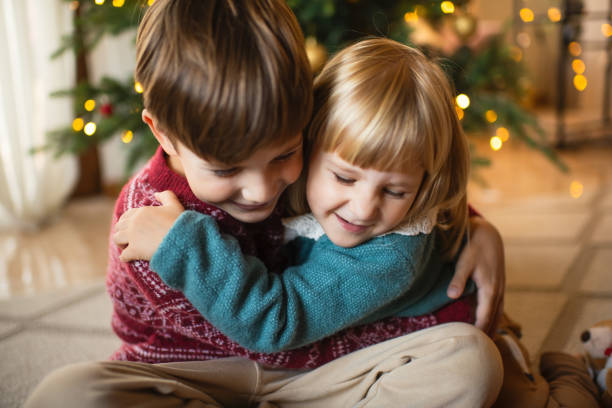 Little boy and girl near Christmas tree