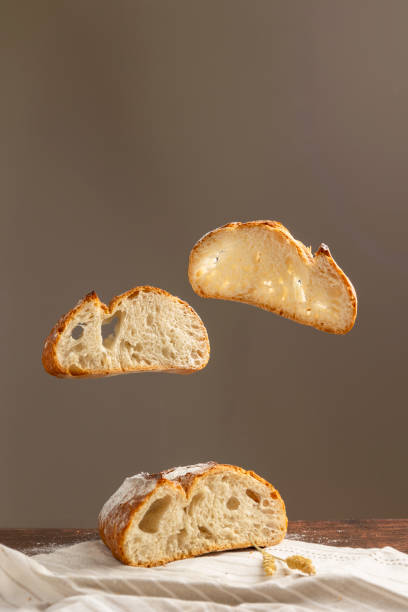 istock Floating bread loaf with flour dust against brown background 2184303994