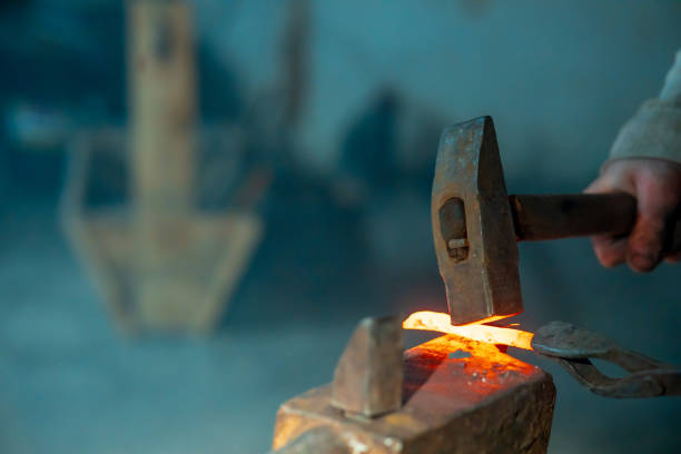 closeup on farrier making a traditional horseshoe on a forge