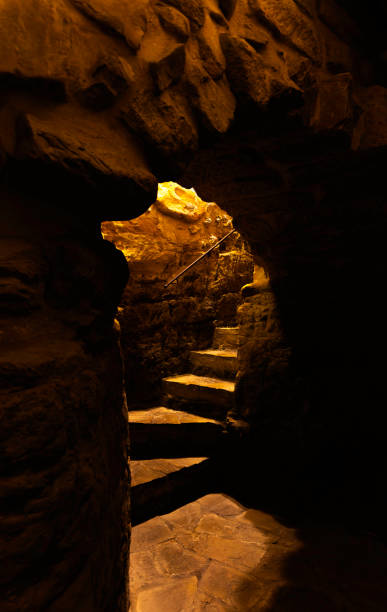 istock A dark cave with a spiral staircase leading up 2184304986