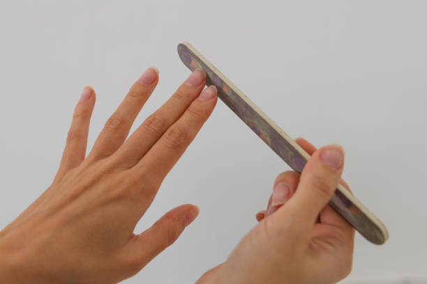 istock Manicurist using a nail file in a beauty salon. 2184305595