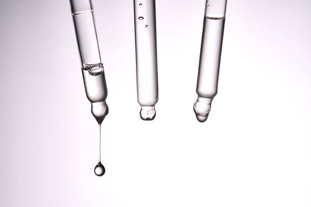 istock Three pipettes with a cosmetic product. Serum or fluid drips from one of them. 2184307436