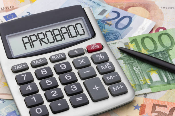 istock Calculator with money and a pen - Approved in spanish 2184308102