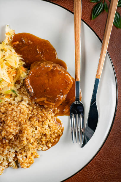 istock Stewed pork neck in gravy served with barley groats. 2184308783