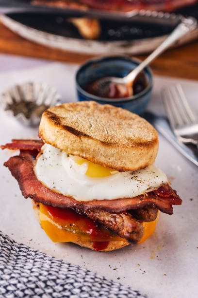 istock English Muffins with  Fried Egg, Sausages, Bacon and Melted Cheese. 2184309135