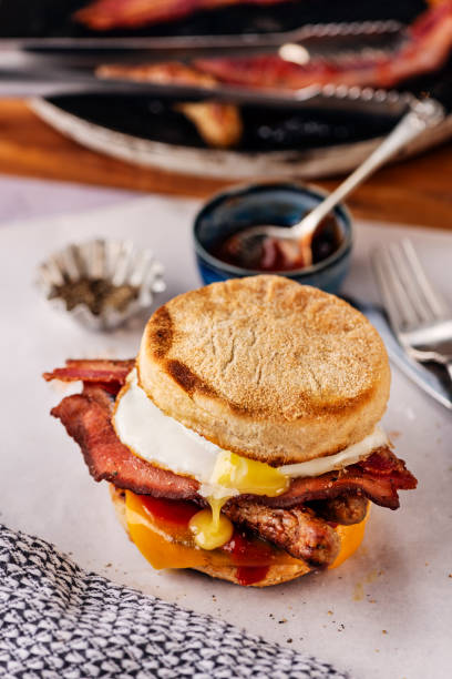 istock English Muffins with  Fried Egg, Sausages, Bacon and Melted Cheese. 2184309154