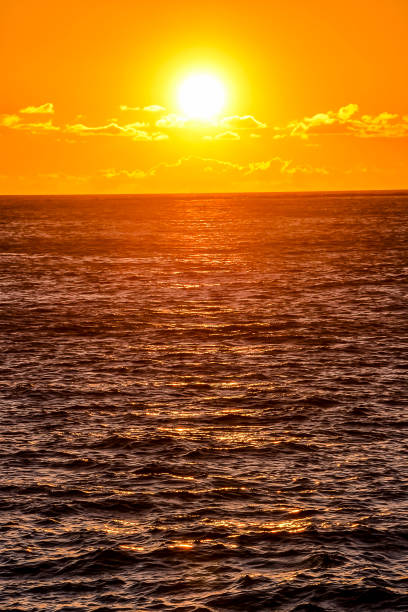 istock The sun is setting over the ocean, casting a warm glow on the water 2184311512