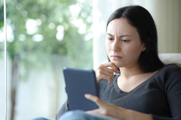 istock Confused asian woman reading ebook 2184312348