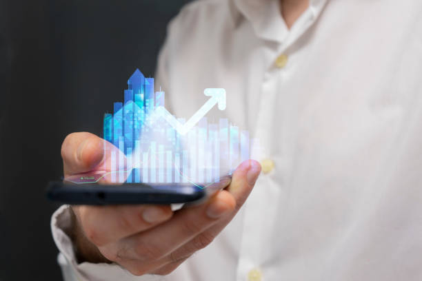 istock Businessman holding a smartphone in his hands with a graph on the screen 2184318667