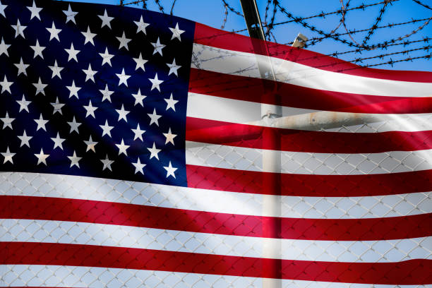 istock US border wall policy. Prevent illegal immigration and enhance security. National defense. American flag and barbed wire fence. Protection and control. Combat drug trafficking and protect sovereignty. 2184321838