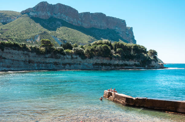 Cassis, France - July 24, 2010: People enjoying a sunny day by the sea with a scenic view of Cap Canaille.