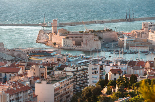 Marseille, France - July 23, 2010: Sunset view of Notre-Dame de la Garde with the city’s vibrant streets and old port below.