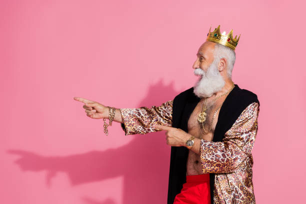 istock Photo of eccentric grandfather king crow leopard robe indicate fingers empty space isolated on pink color background 2184332038