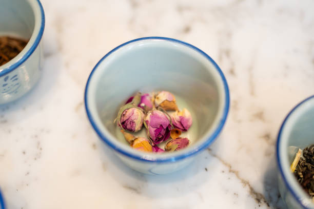 Teacup filled with dried pink rosebuds.