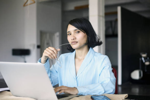 istock A young woma at work looking to camera at her workspace 2184337534