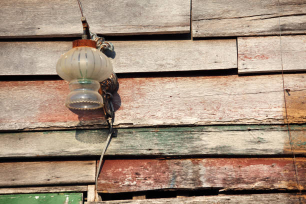 istock Vintage Glass Lantern Hanging on Weathered Wooden Wall in Rustic Setting with Peeling Paint and Texture Details for Authentic Atmosphere 2184340378