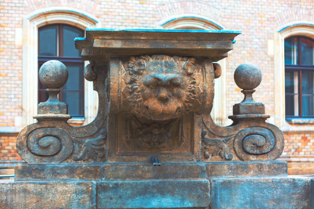 Stone fountain featuring a lion head, elegantly designed with flowing water. Baroque Carrati Public Fountain in Prague. Carratiho Kasna