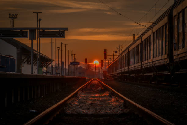 Sunset with railway track and railroad switch semaphore silhouette and trains in Chocen CZ 11 08 2024