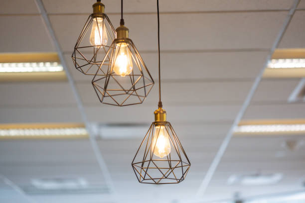 istock Three lighted vintage lamps hanging from the ceiling in office. 2184345594