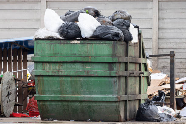 istock A green dumpster is full of trash, including plastic bags 2184345746