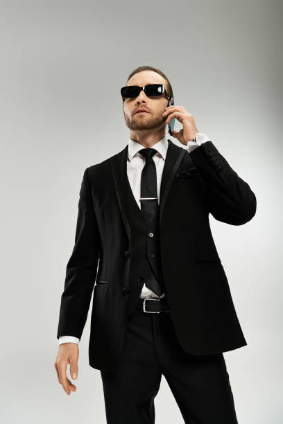 istock Young man in formal attire speaks on the phone with confidence in a modern studio setting 2184348491